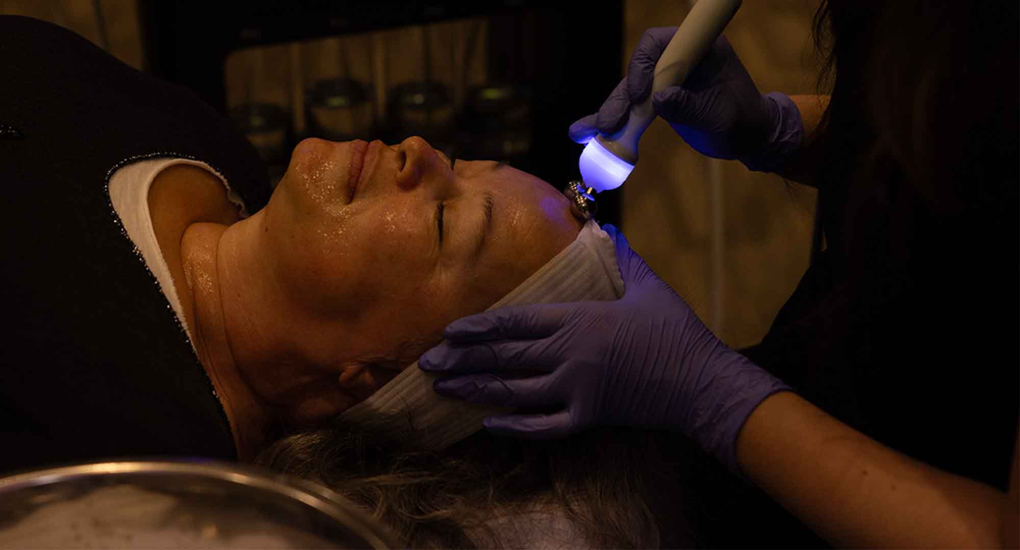 photo of an esthetician applying a light tool as a demonstration